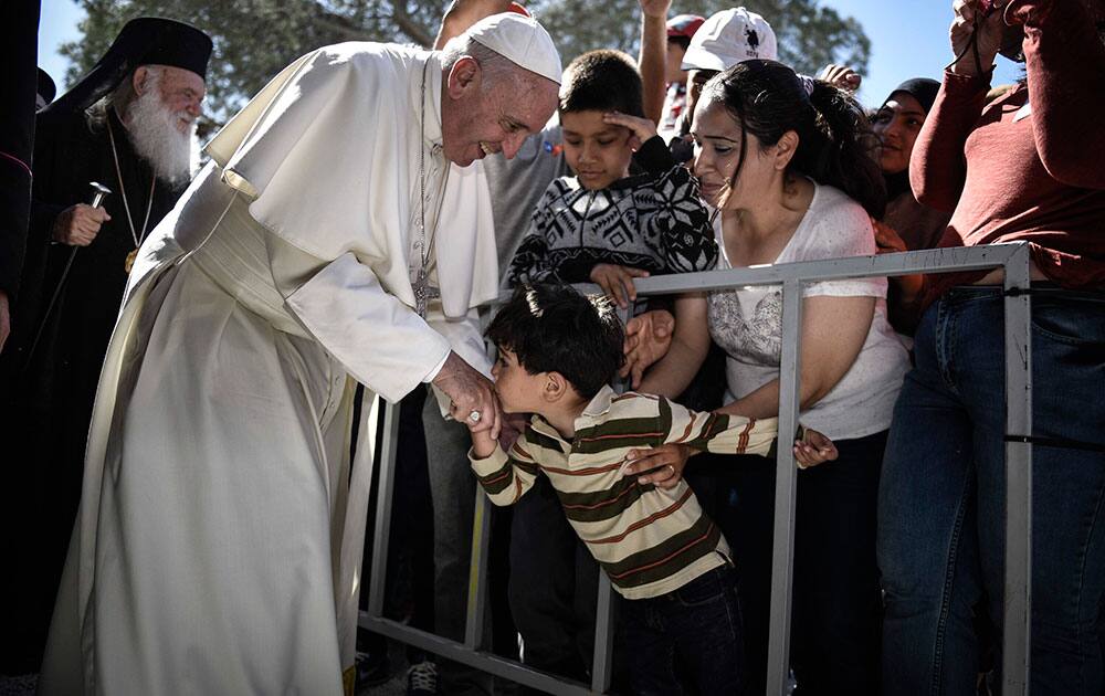a child kisses the hand of Pope Francis, during a visit at the Moria refugee camp on the island of Lesbos, Greece. Pope Francis implored Europe to respond to the migrant crisis on its shores 
