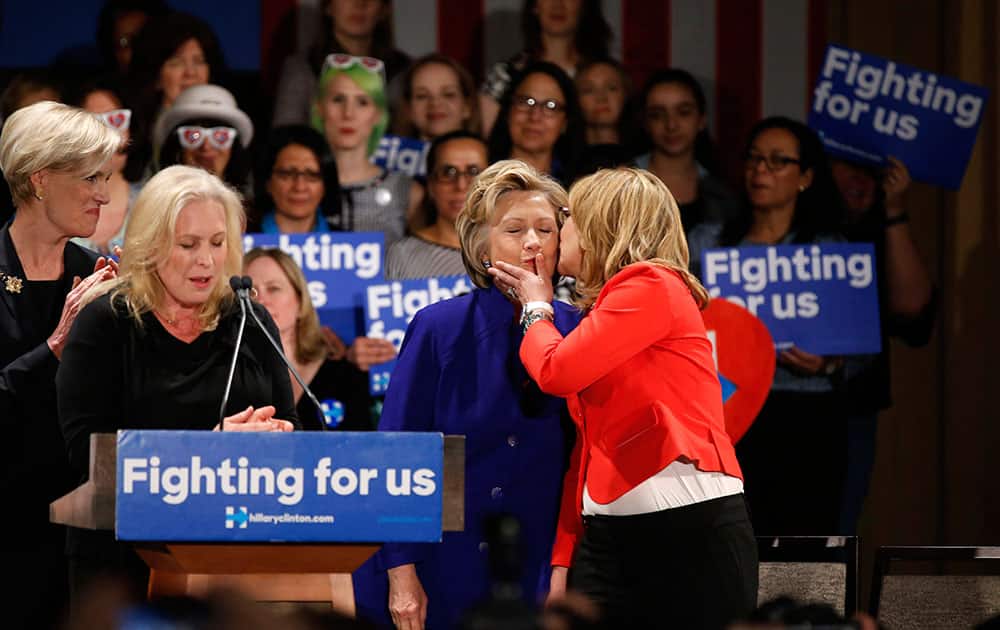 Former Arizona Rep. Gabby Giffords plants a kiss on the cheek of Democratic presidential candidate Hillary Clinton at a Women for Hillary campaign event, in New York. 