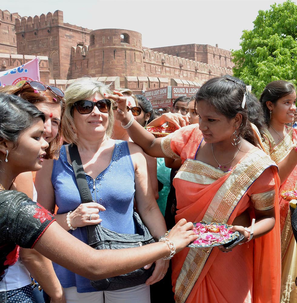 Tourists being welcomed by girls on the occasion of World Heritage Day in Agra.