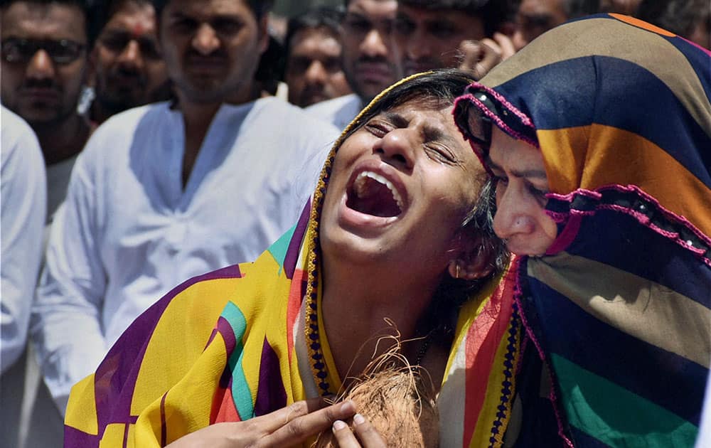 The wife of Bhavin Khunt mourns his death during his funeral procession in Surat. 
