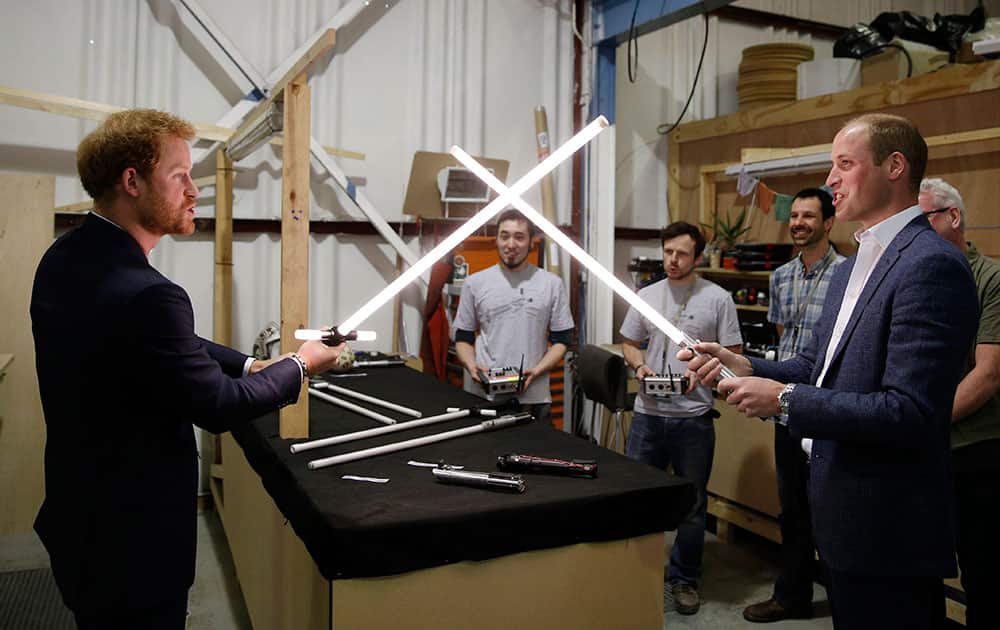 Britains Prince William, right, and Prince Harry use light sabres during a tour of the Star Wars sets at Pinewood studios in Iver Heath, west London.
