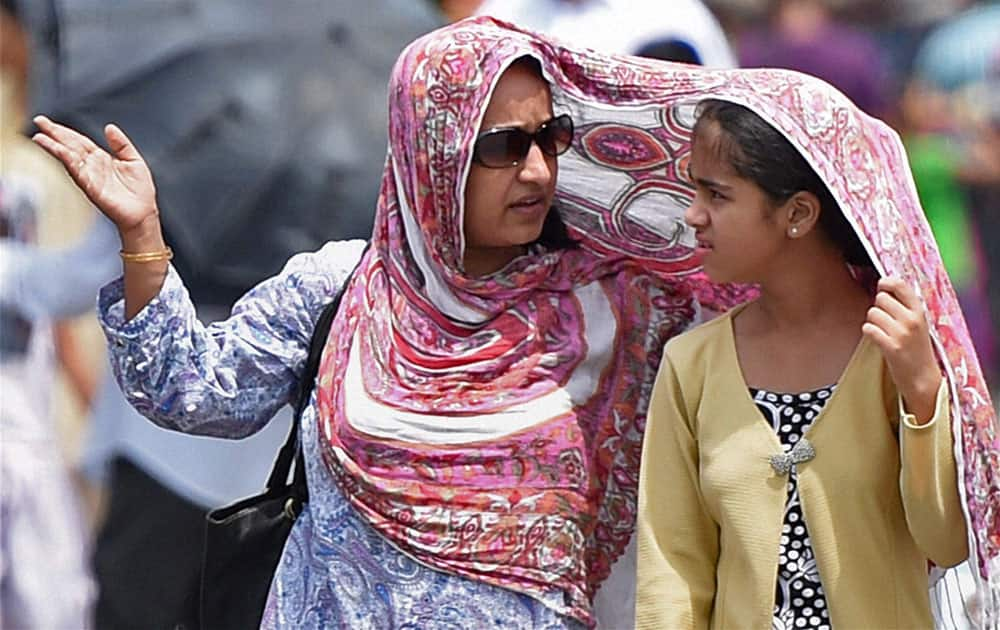 Women cover themselves during a hot sunny day in Mumbai.