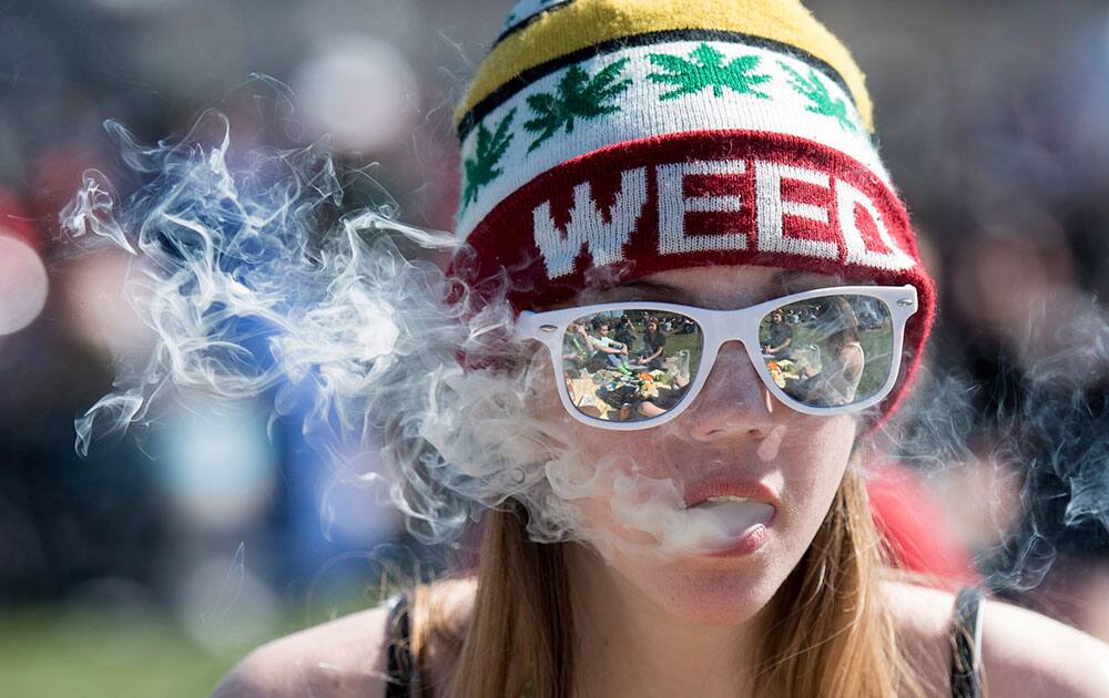 A woman exhales while smoking marijuana during the annual 420 marijuana rally on Parliament Hill in Ottawa, Canada.