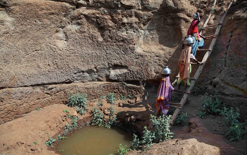 Women collect water from an almost dried up well at a village in Surgana Taluka, around 95 kms from Nasik.