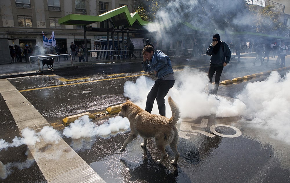 A student kicks a tear gas canister during a protest demanding that the government make true its promise of free education, in Santiago, Chile.