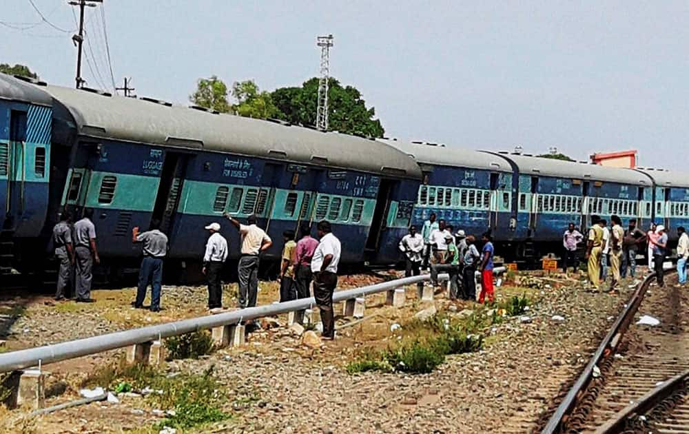 People gather at the accident site where two trains collided in Hubli