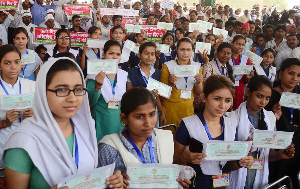 Girls showing their demnad drafts received from UP CM Akhilesh Yadav under Kanya Vidhyadhan scheme at a rally at Iradatganj village near Allahabad.