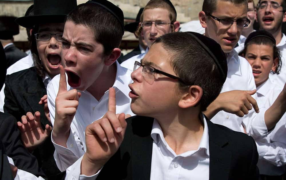 Ultra-Orthodox Jewish youth yell at a journalist covering the Jewish women's prayer during the Jewish holiday of Passover in front of the Western Wall, the holiest site where Jews can pray, in Jerusalem's Old City.