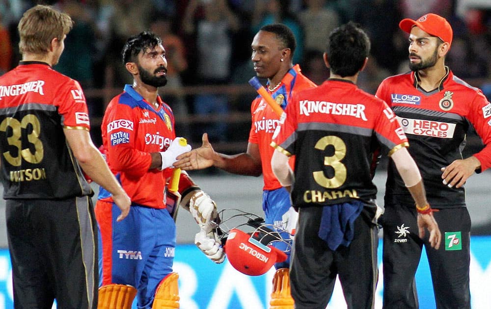 Gujarat Lions players Dinesh Karthik and Dwayne Bravo after winning IPL match against Royal Challengers Bangalore in Rajkot.