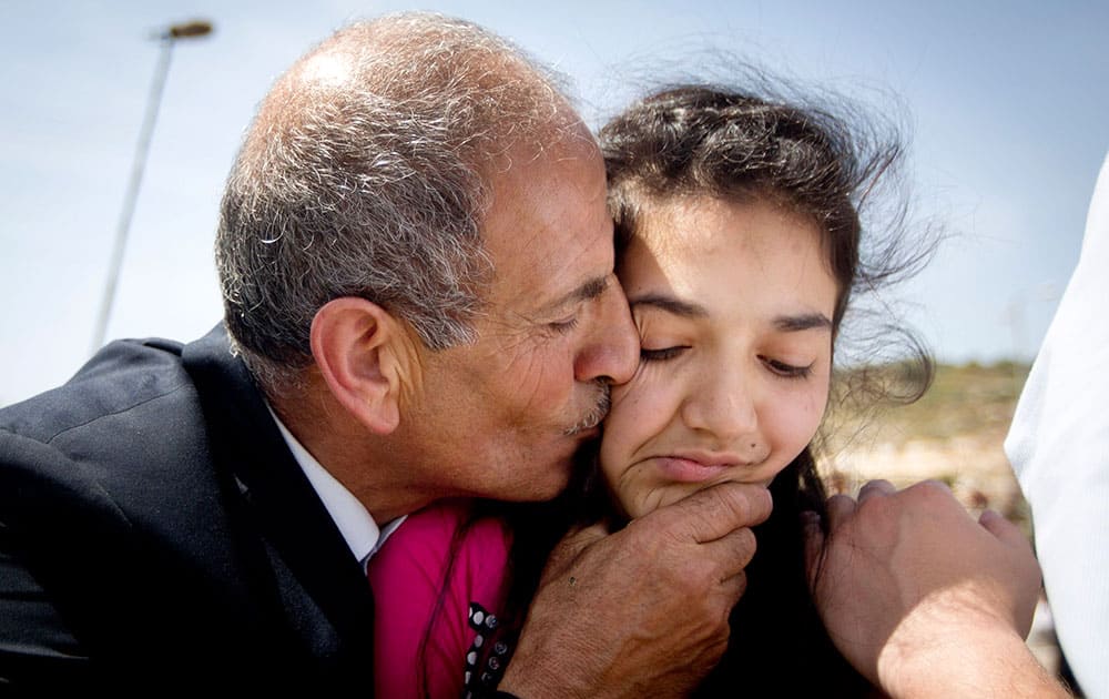 Palestinian father Ismail al-Wawi kisses his 12-year-old daughter Dima al-Wawi, who was imprisoned by Israel for allegedly attempting to carry out a stabbing attack, after her release from an Israeli prison, at Jabara checkpoint near the West Bank town of Tulkarem.