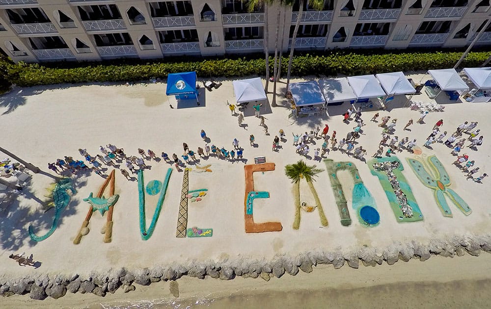 In this aerial photo provided by the Florida Keys News Bureau, sand sculpturists stand by their creations at the Cheeca Lodge Resort in Islamorada, Fla.