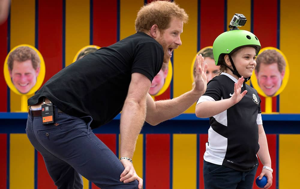 Britain's Prince Harry takes part in filming a segment where a photo of him is printed on some of the targets children had to throw balls at for an episode of the Sky Sports 'Game Changers' television show dedicated to the Invictus Games at Lambs Lane Primary School in Spencers Wood, near Reading, England.