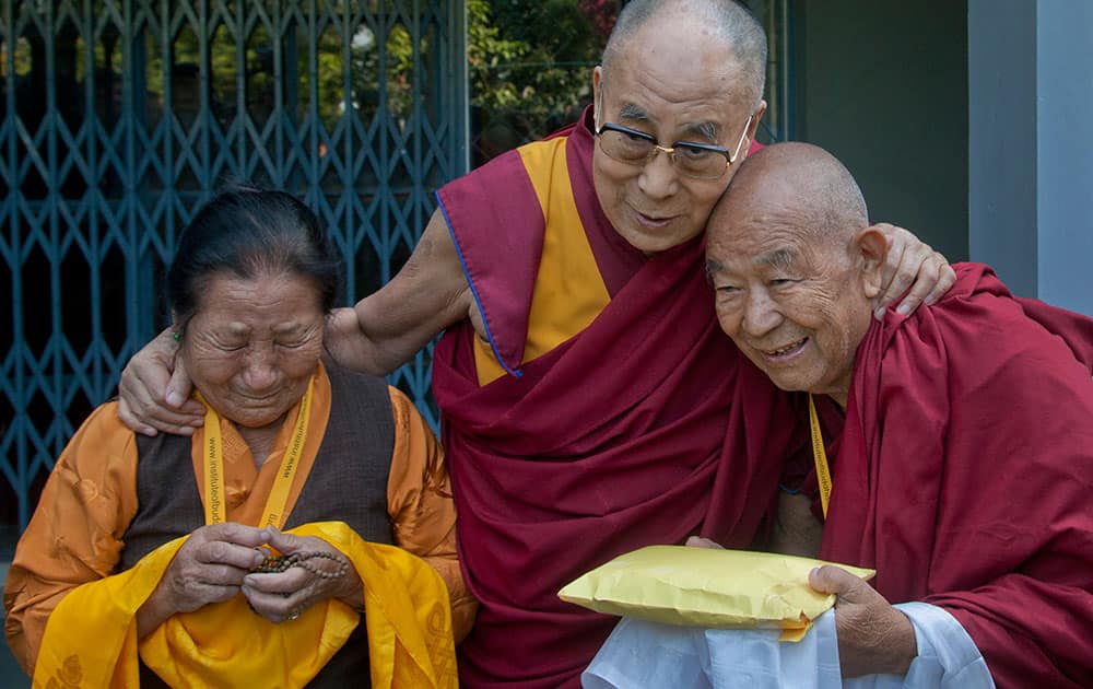 An elderly Tibetan woman, left, who was among those waiting to receive the Dalai Lama, gets emotional as the spiritual leader greets devotees upon arrival at the Institute of Buddhist Dialectics near Dharmsala.