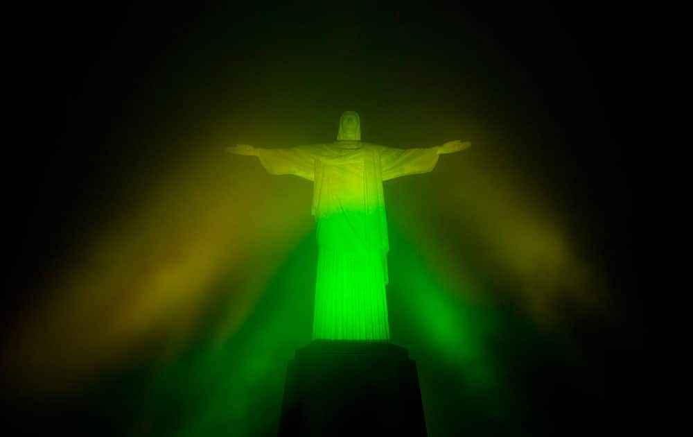 The Christ the Redeemer statue is lit in green and yellow to mark 100 days left to the Olympic Games in Rio de Janeiro, Brazil.