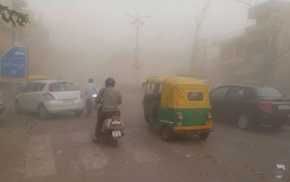 Vehcle plying at a road during a sand torm in Gurgaon.