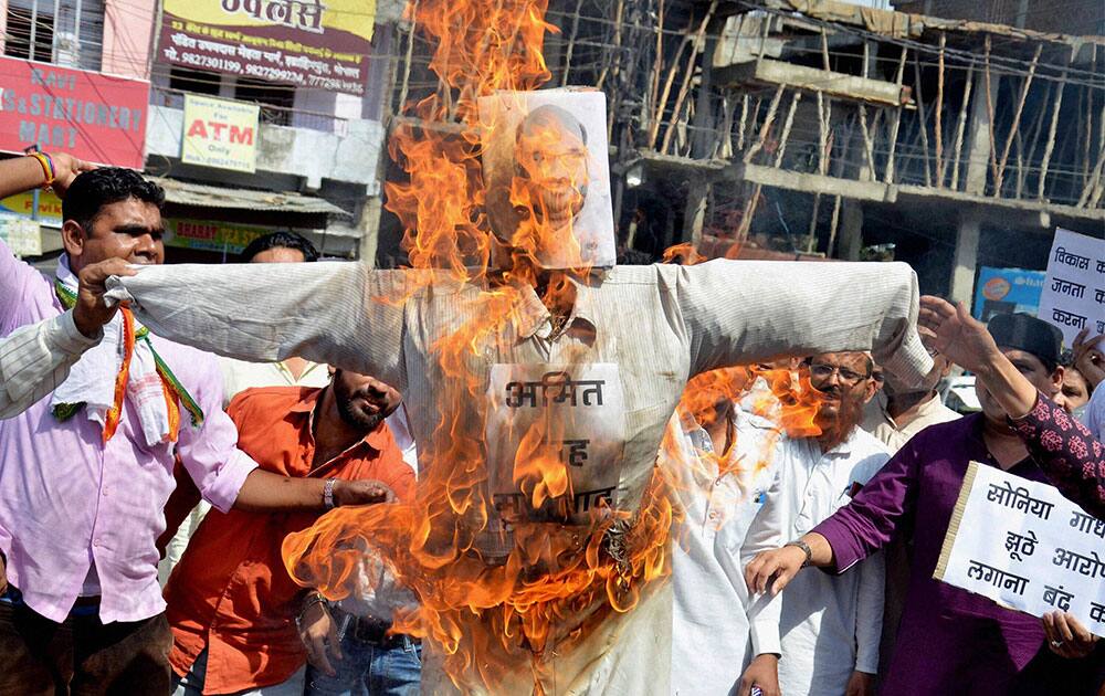 Madhya Pradesh Congress party workers burn an effigy of BJP National President Amit Shah for his remarks on party president Sonia Gandhi in connection with AgustaWestland purchase, at a protest in Bhopal.