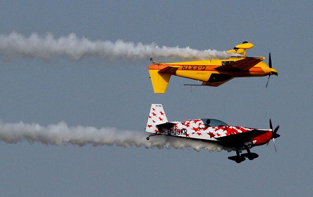 Aircrafts of the British aerobatics team Global Stars perform their flying skills during the inauguration of three-day air show in Ahmadabad.