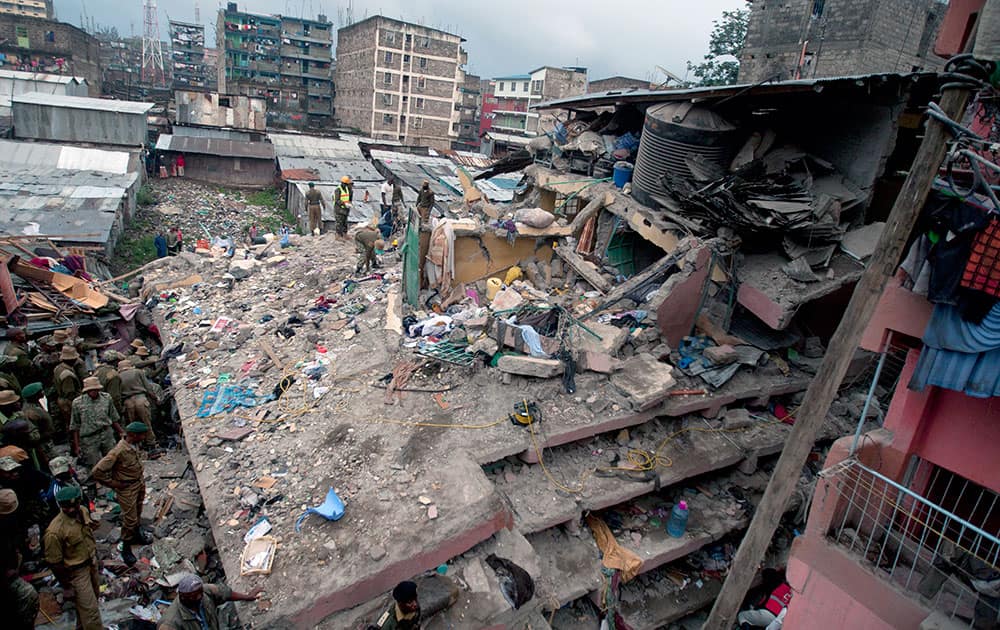 Kenyan police officers and Kenyan National Youth Servicemen search the site of a building collapse in Nairobi, Kenya.