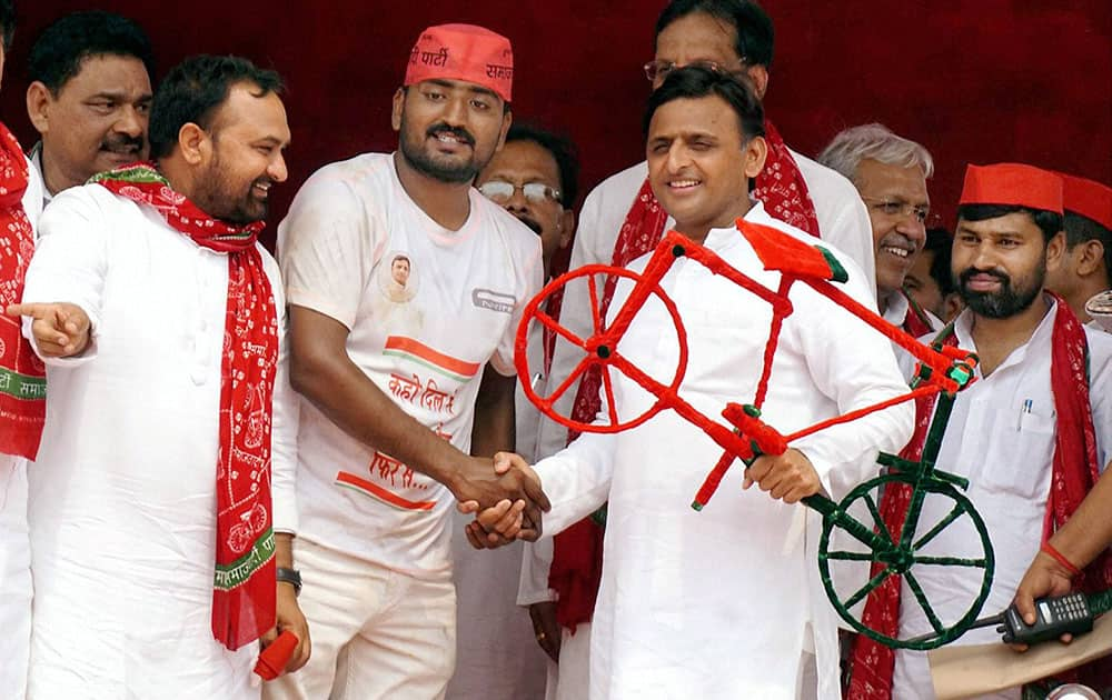 UP Chief Minister Akhilesh Yadav is presented a model of Samajwadi Party symbol cycle by supporters during a public meeting in Ballia.