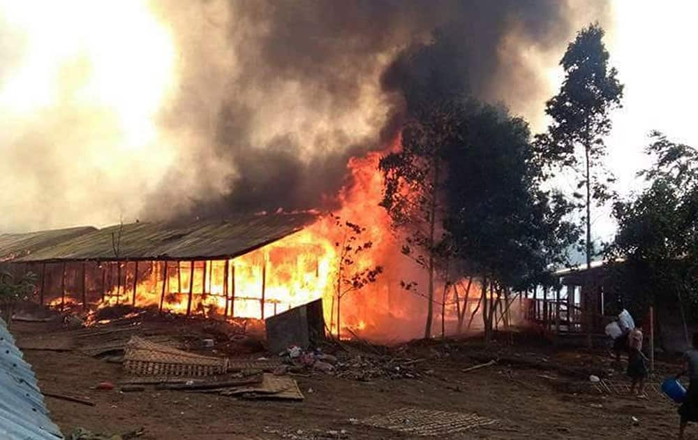 People throw water at a fire in Baw Du Pa camp, a camp for stateless Rohingya people in north of Sittwe, western Rakhine state, Myanmar. A fire burned down a camp in western Myanmar that shelters members of the country's persecuted Rohingya minority, leaving 440 families homeless.