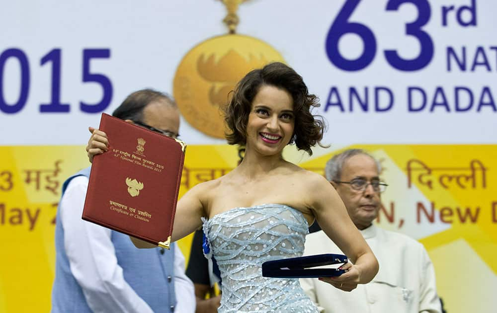 Actress Kangana Ranaut shows her national award for best actress after receiving it.