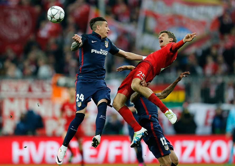 Atletico's Jose Maria Gimenez, left, and Bayern's Thomas Mueller go for a header during the Champions League second leg semifinal soccer match between Bayern Munich and Atletico de Madrid in Munich, Germany.