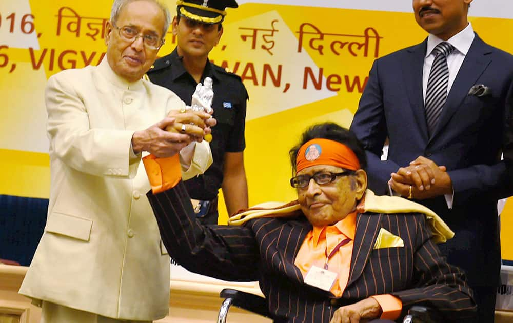 Veteran actor Manoj Kumar presenting a memento to President Pranab Mukherjee while receiving Dadasaheb Phalke Award from him at the 63rd National Film Awards 2015 function in New Delhi.