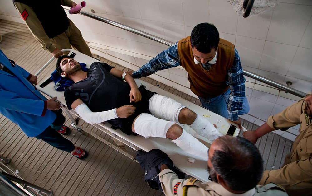 Indian policemen and paramedics carry a wounded policeman for treatment at a local hospital in Srinagar, Kashmir.