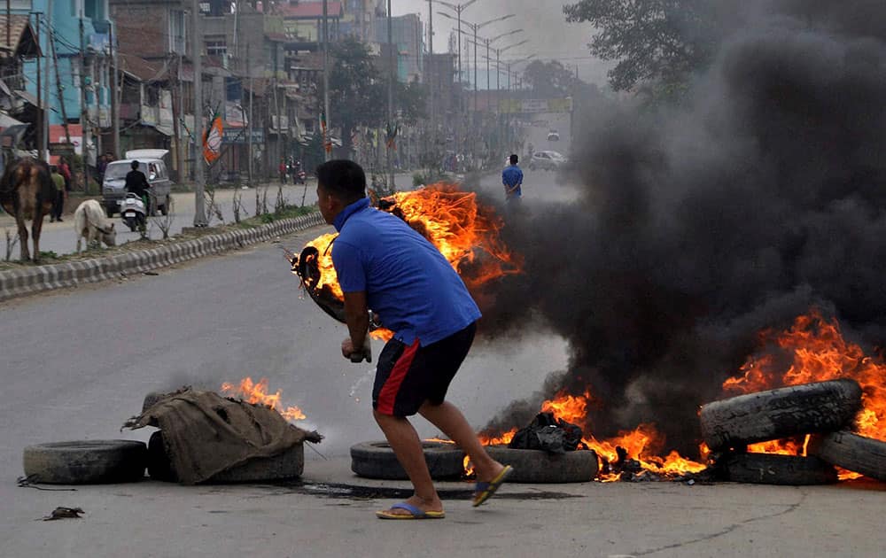 A youth blocks a road during a public curfew called by the Joint Committee on Inner Line Permit System (JCILPS) in Imphal.