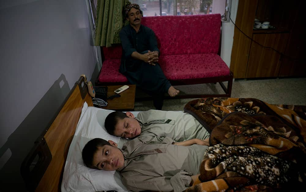 In this photo Abdul Rasheed, 9, front, and Shoaib Ahmed, 13, lie in a bed at a hospital in Islamabad, Pakistan. The boys are normal active children during the day. But once the sun goes down, they both lapse into a vegetative state — unable to move or talk.