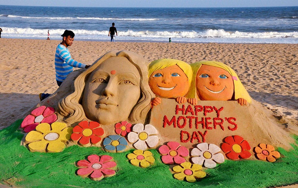 Sand artist Manas Kumar Sahoo create a sand sculpture on eve of Mother’s day in Puri.
