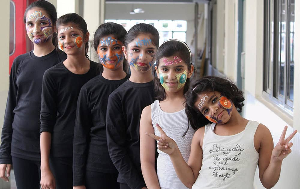 Girls paint faces expressing love for their mothers on the eve of Mothers Day in Gurgaon.