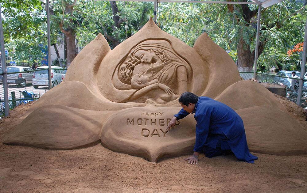 Sand artist Subal Moharana giving a finishing touch to a sand art on the eve of Mothers day in Bhubaneswar, Odisha.