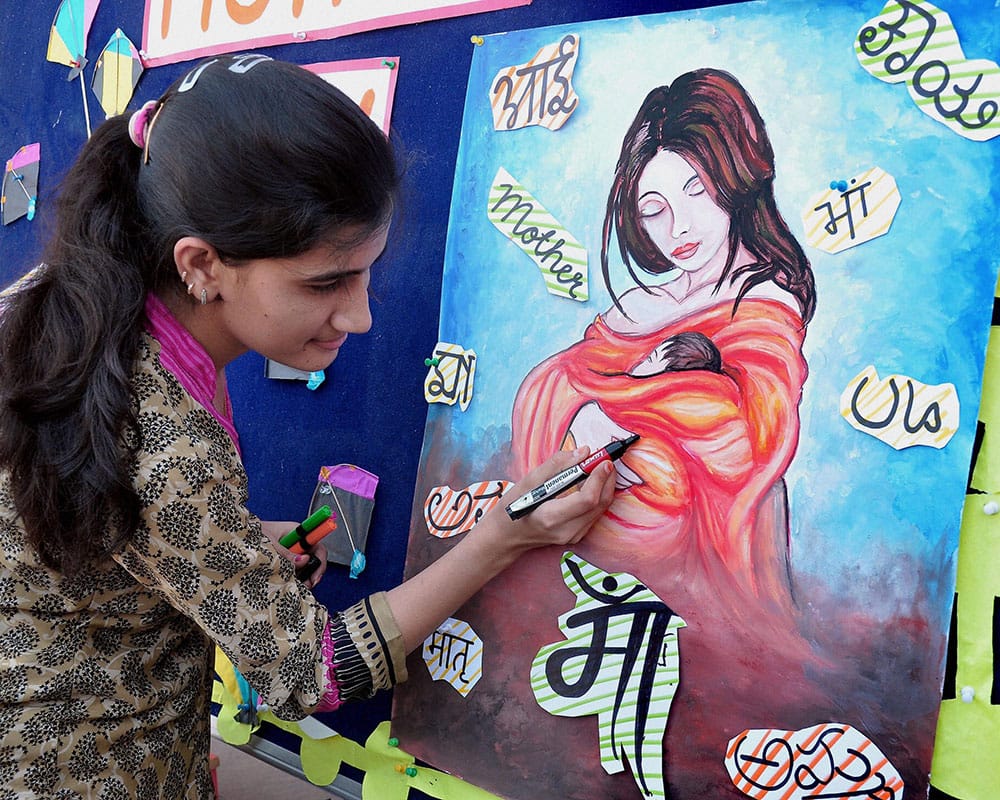 A school teacher drawing a poster Maa on the eve of mothers day in Bikaner, Rajasthan.