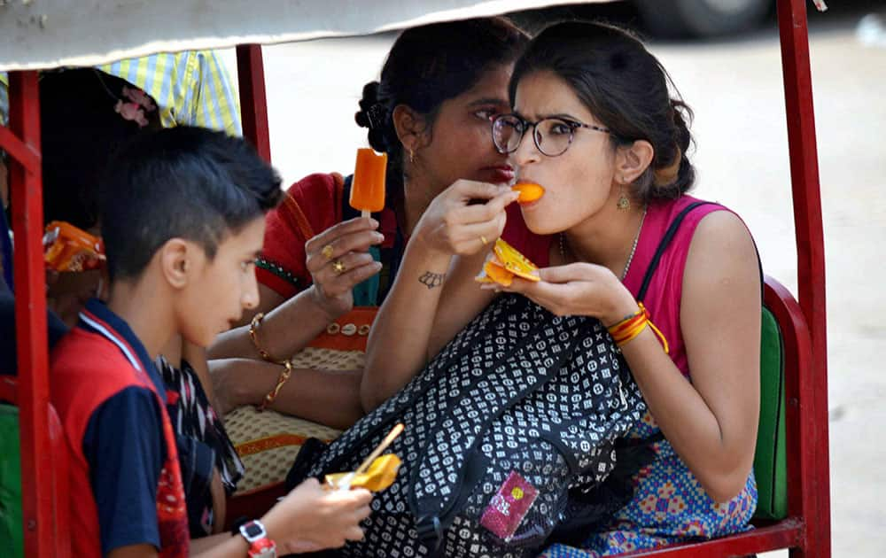 Girls trying to beat the heat with ice candies in Agra.