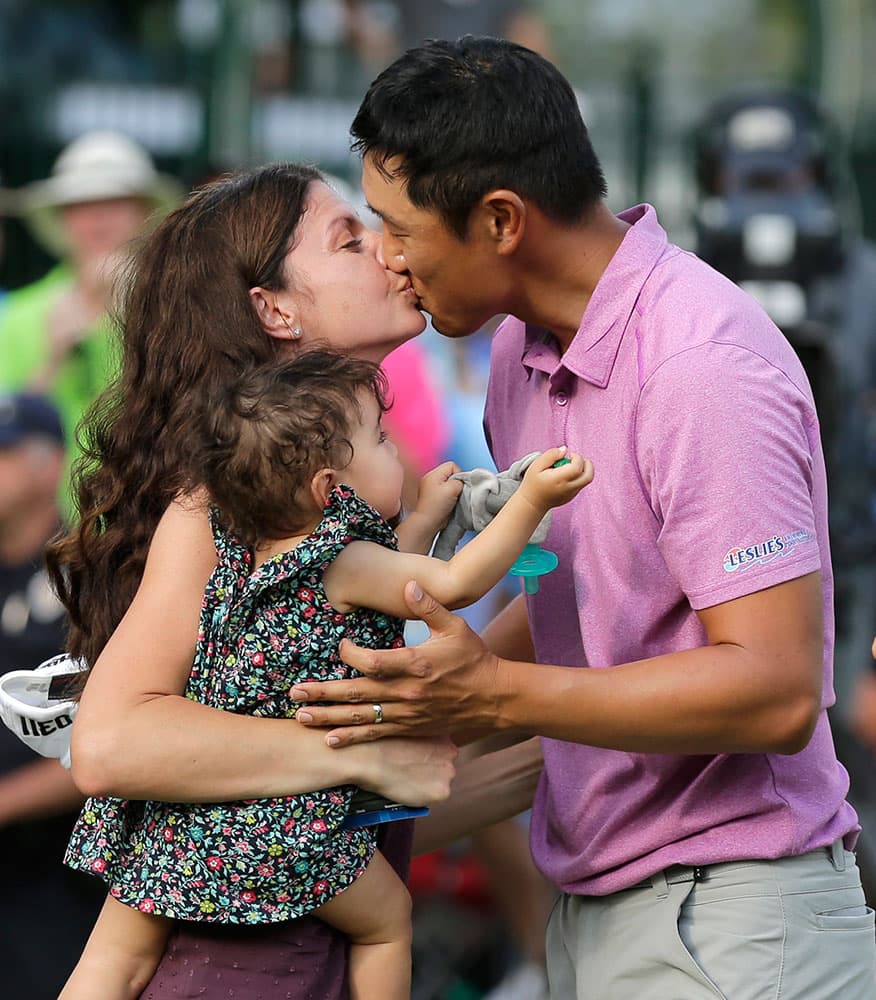 James Hahn, right, gets a kiss from his wife Stephanie and their daughter Kailee, center, watches after winning the Wells Fargo Championship golf tournament at Quail Hollow Club in Charlotte, N.C.