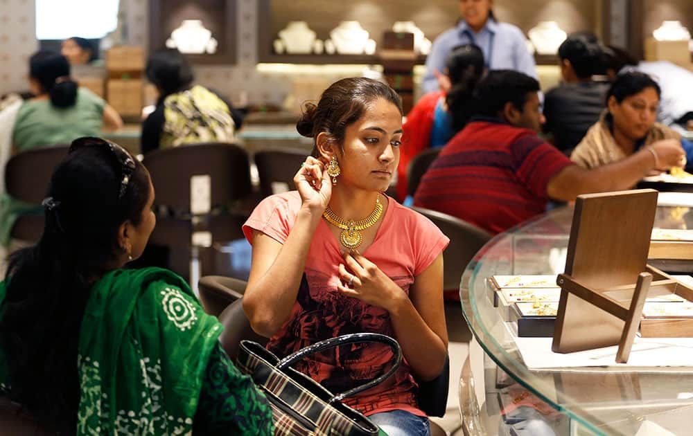 A woman tries on a gold earring at a jewelry shop in Ahmadabad. Monday marks the Hindu festival Akshay Tritiya, the birthday of Lord Parasurama who is the sixth incarnation of Lord Vishnu, which is considered auspicious for buying gold among other things.