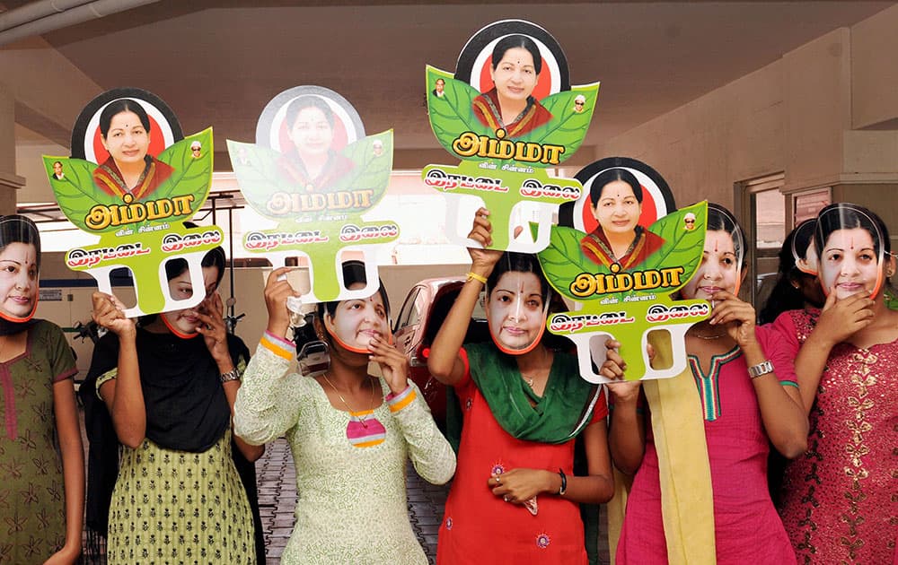 College students wear the face mask of AIADMK Supremo and Tamil Nadu Chief Minister J Jayalalithaa during an election campaign rally in Coimbatore.
