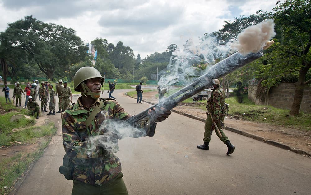 A riot policeman fires tear gas towards opposition supporters during a protest in downtown Nairobi, Kenya.