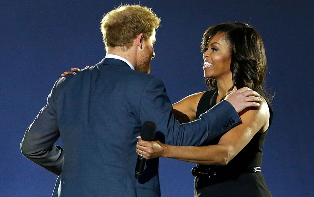 Britain's Prince Harry, left, greets first lady Michelle Obama on stage during the opening ceremony for the Invictus Games.