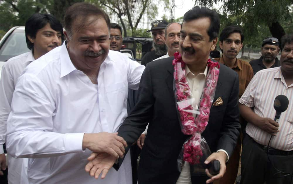 Pakistan's former Prime Minister Yusuf Raza Gilani, center, is greeted by supporters upon arrival at his residence in Islamabad, Pakistan.