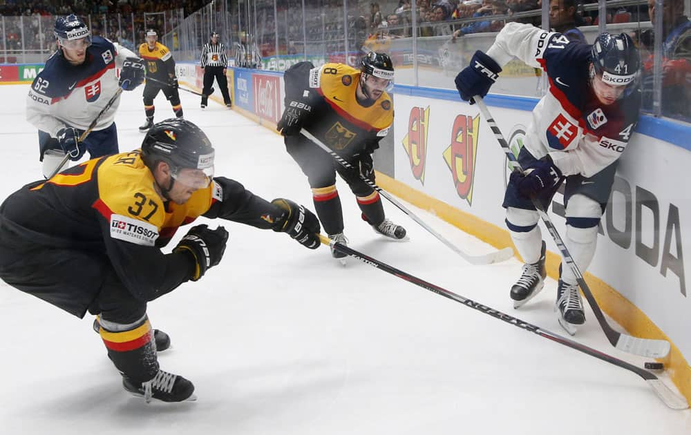 Germany’s Patrick Reimer, left,fights for the puck with Slovakia’s Patrik Lusnak during the Hockey World Championships Group B match in St.Petersburg, Russia.