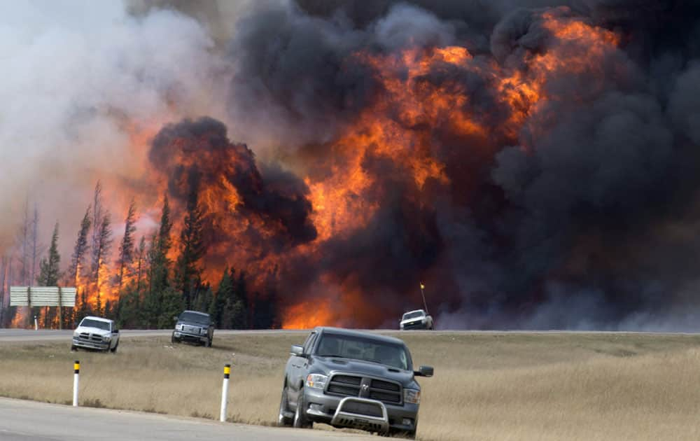 wildfire burns south of Fort McMurray, Alberta. A dry and blistering hot northern Alberta is burning and doing so unusually early in the year,
 but that’s only the latest of many gargantuan fires on an Earth that’s grown hotter with more extreme weather.