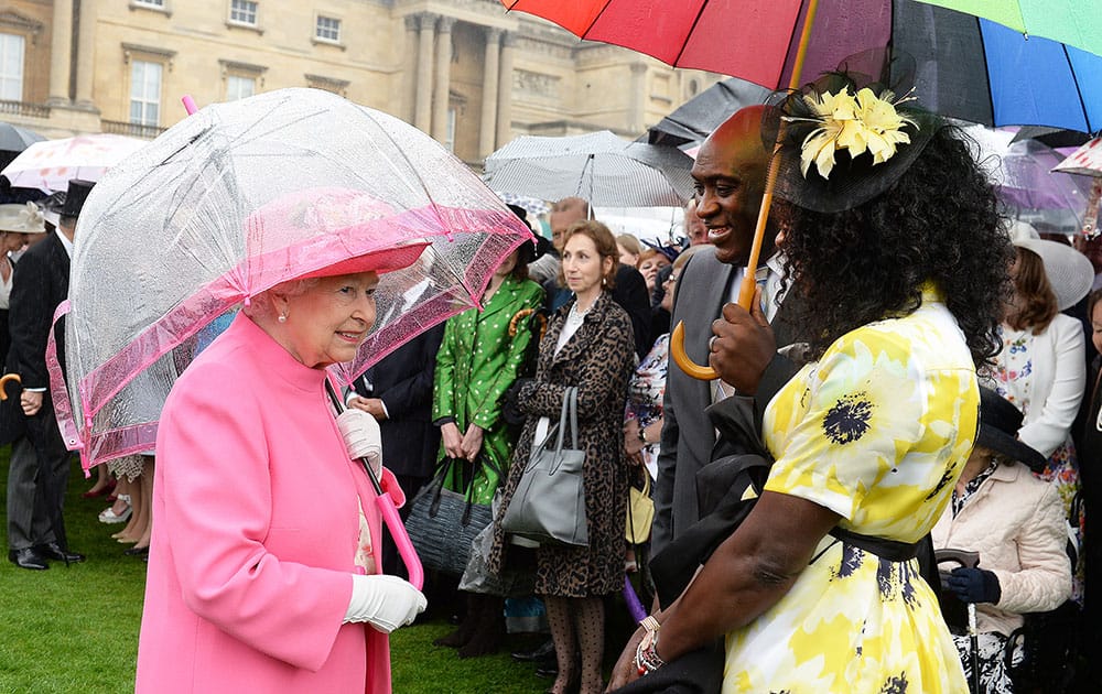 Britain's Queen Elizabeth II talks to Pastor Kofi Banful and Jayne Banful at a garden party at Buckingham Palace in London.