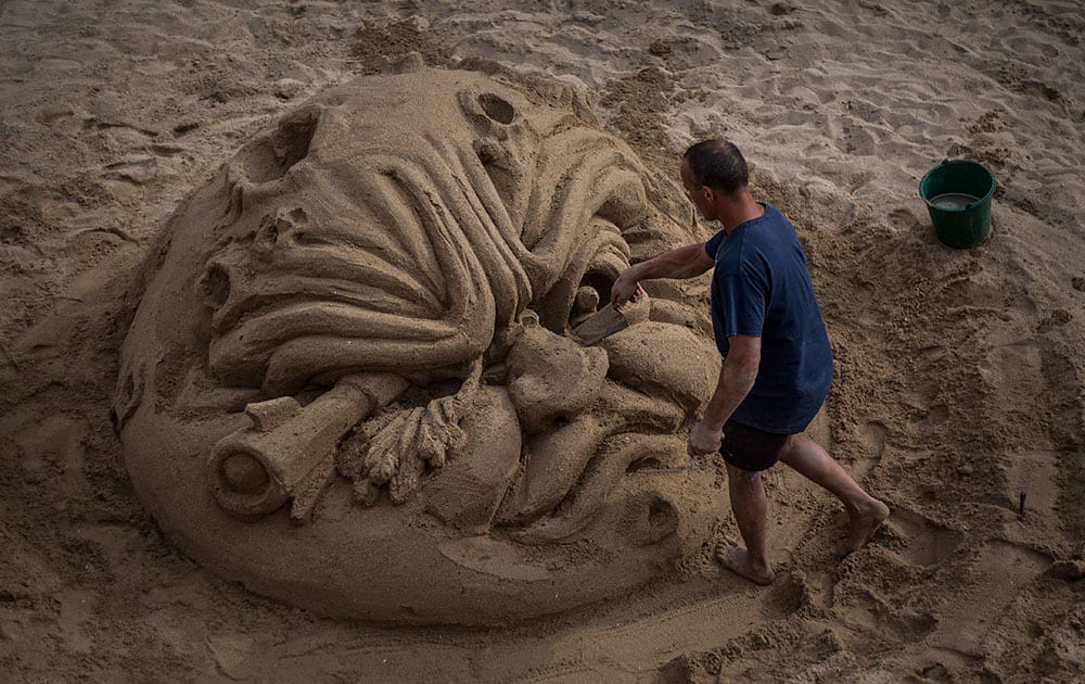 A beach artist creates an image made from sand on the beach in front of the entrance of the Festival Palace in Cannes southern France.