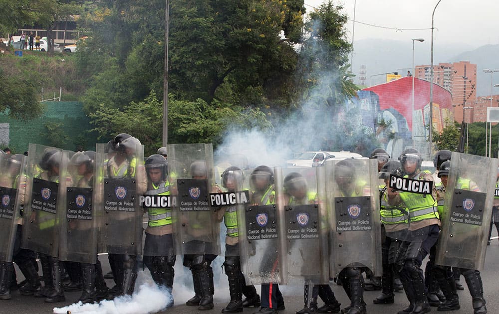 Bolivarian National Police advance as they fire tear gas at anti-government protesters to keep them from reaching the National Electoral Council (CNE) in Caracas, Venezuela.