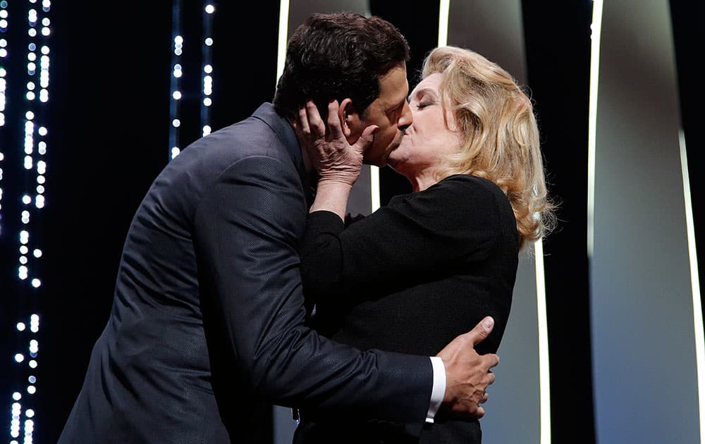 Actors Laurent Lafitte, left, and Catherine Deneuve kiss at the Opening Ceremony at the 69th international film festival, Cannes.