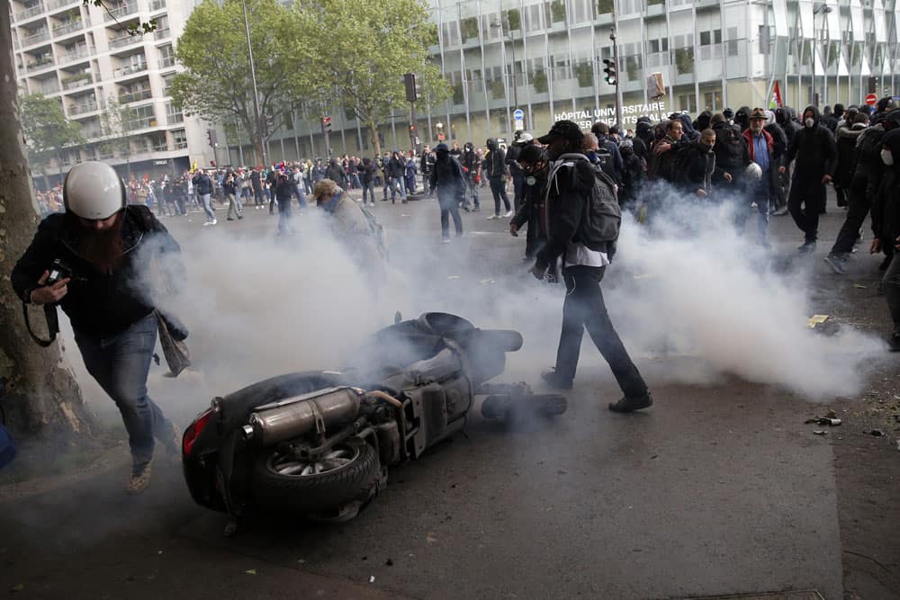 Demonstrators clash with French police officers during a protest against Labor Law as the Socialist government decided to force the bill through Parliament without a vote, in Paris.