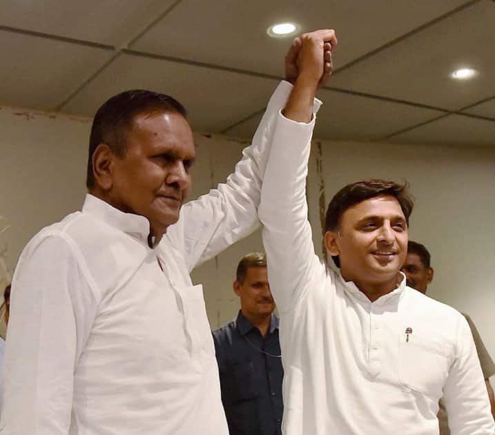 Beni Prasad Verma (left) raise hands with Chief Minister Akhilesh Yadav (right) after joining Samajwadi party in Lucknow.