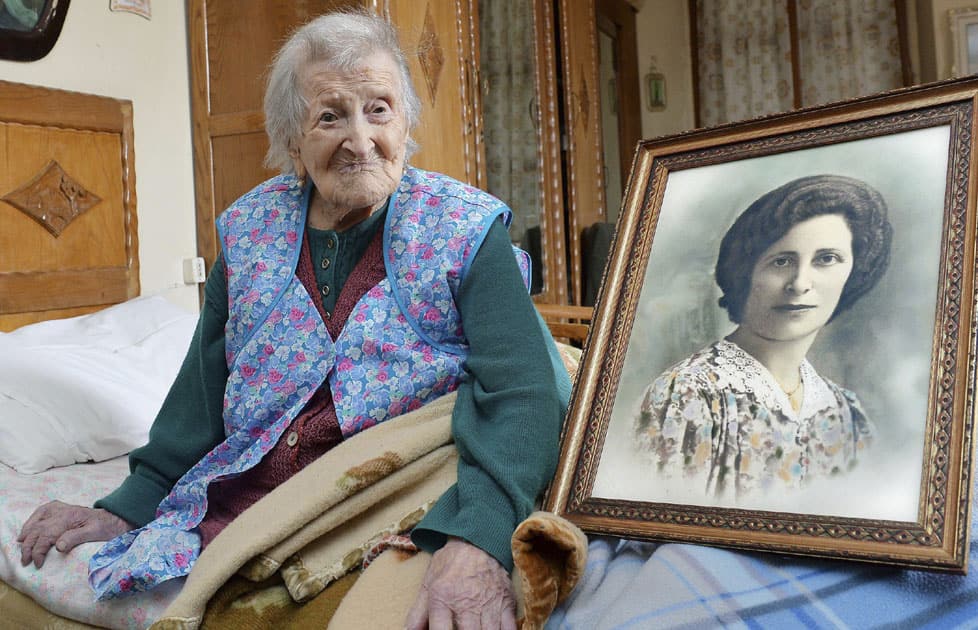 Emma Morano poses next to a picture depicting her when she was young, in Verbania, Italy. She is 116 years of age and the oldest person in the world.